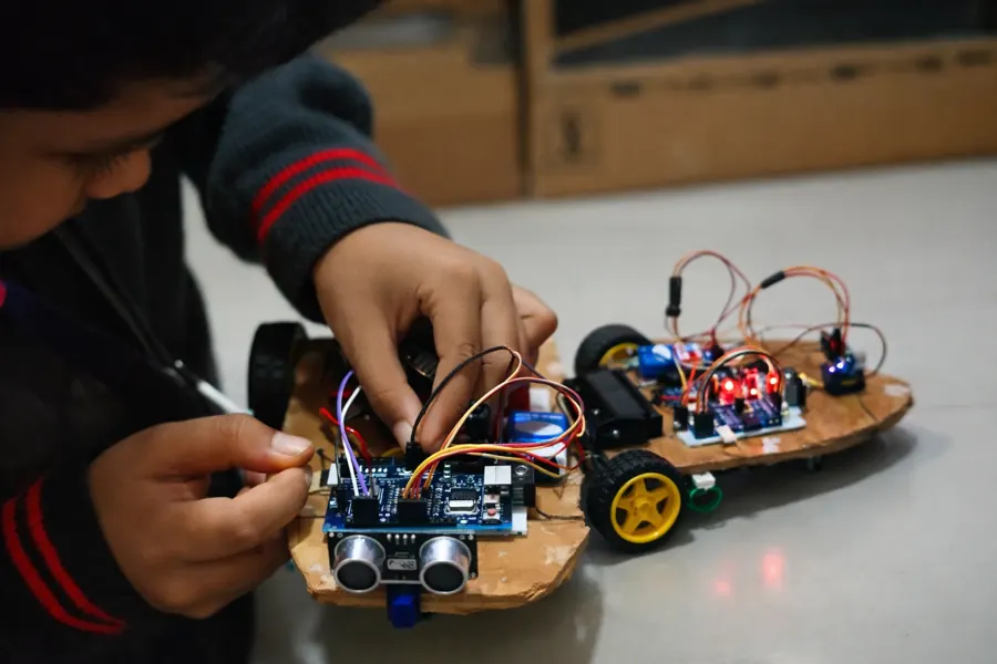 Student assembling an Arduino robot car with ultrasonic sensor